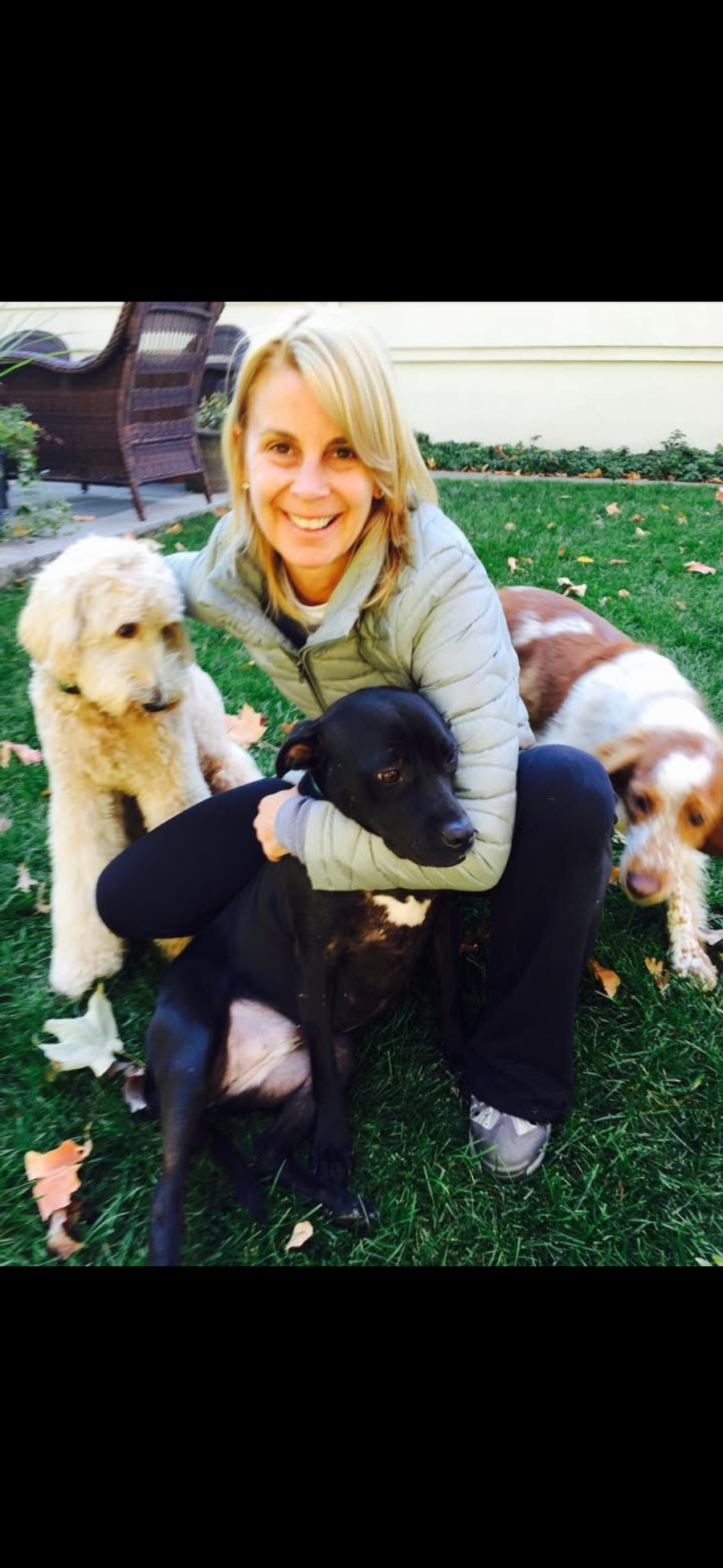 Karen Byrnes hugging a happy black dog